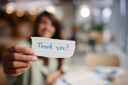 Close up of unrecognizable woman holding thank you note.