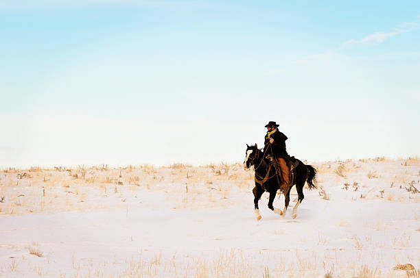 istock Hard Riding Cowboy In Action On Snowy Desert Landscape 182429200