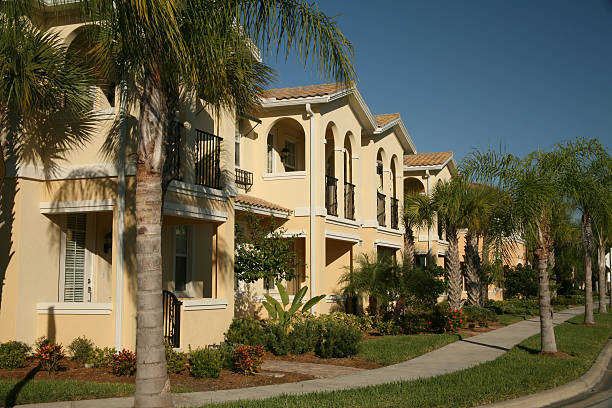 Condominium Neighborhood Neighborhood of newly constructed two-story condominiums. Palm Trees and sidewalk. beautifull vacational rental homes stock pictures, royalty-free photos & images