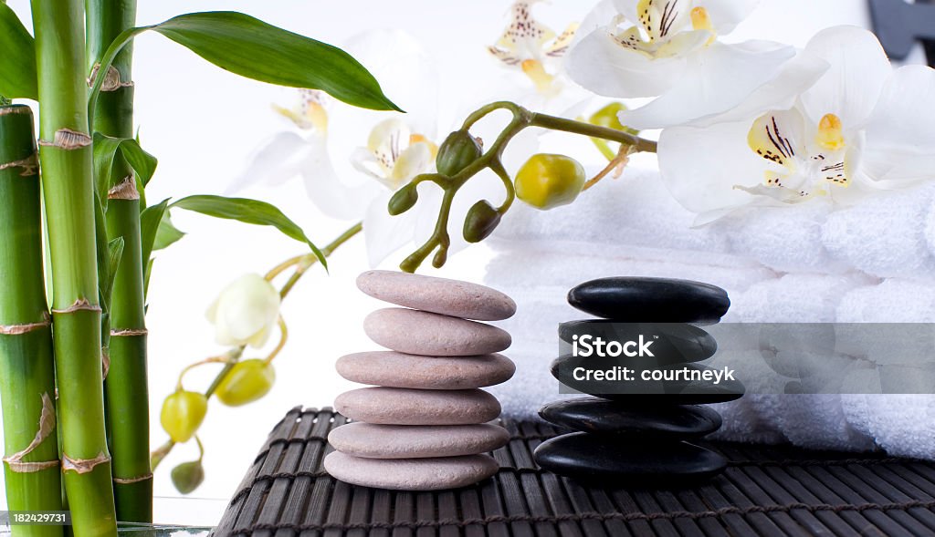 Massaggio pietre equilibrato sul tappeto con asciugamani - Foto stock royalty-free di Cultura cinese