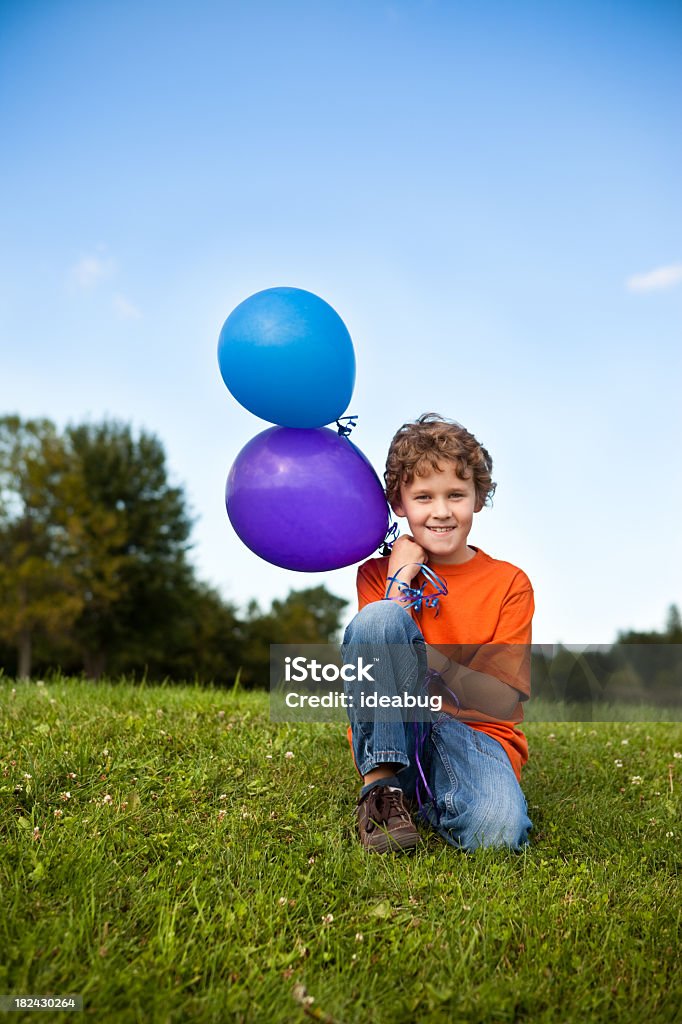 Garoto feliz segurando balões do lado de fora - Foto de stock de 8-9 Anos royalty-free