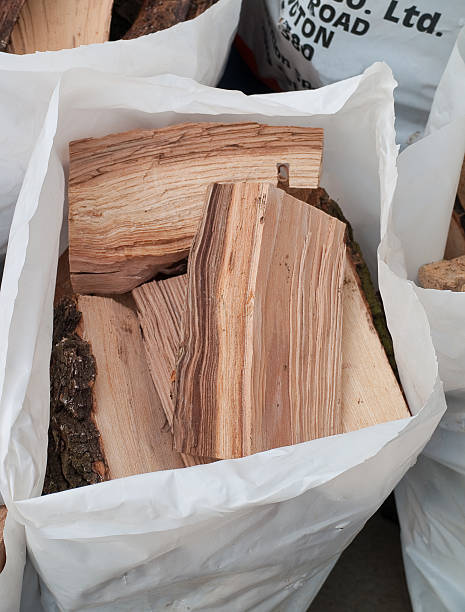 Bags of split logs ready for buring on domestic fires in rural England.
