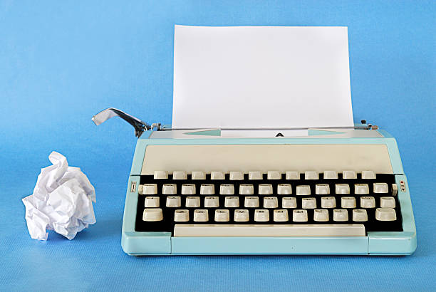 Retro Typewriter Manual Typewriter Circa 1970 with a blank sheet of paper and rejected work alongside typewriter photos stock pictures, royalty-free photos & images