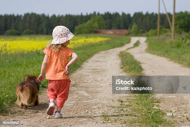 Bambina Con Il Suo Cane A Piedi - Fotografie stock e altre immagini di 12-17 mesi - 12-17 mesi, 18-23 mesi, Ambientazione esterna