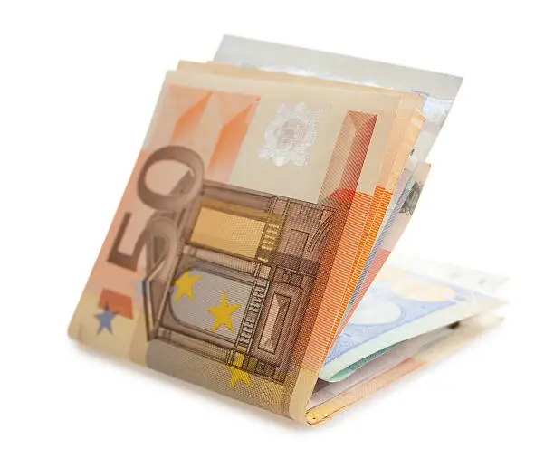 Folded and used Euro banknotes isolated on white background.