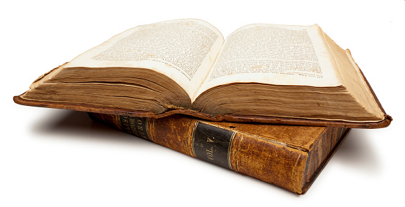 Two antique Leather bound books stacked, the one on top is open. There is a Clipping Path included that will remove the drop shadow.