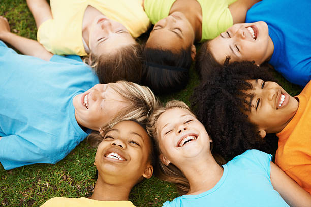istock Happy children lying on grass and laughing 182432074