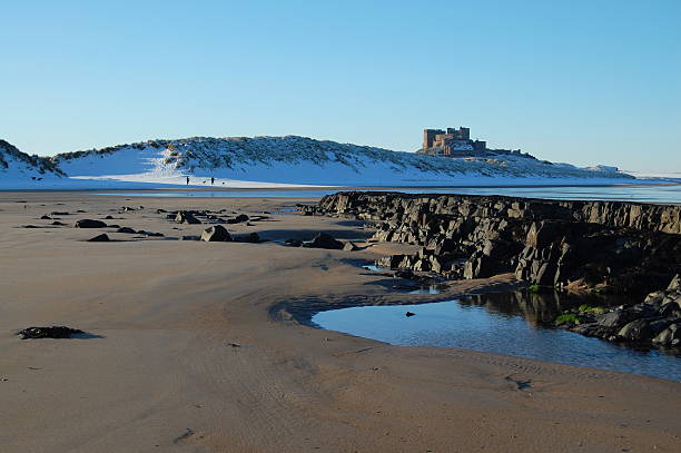 романтический пляж сцена на зимний отпуск - bamburgh castle northeastern england bamburgh castle стоковые фото и изображения