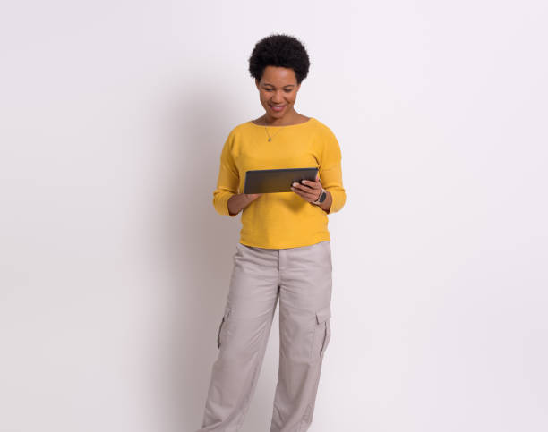 istock Smiling businesswoman working online over digital tablet while standing isolated on white background 1824331156
