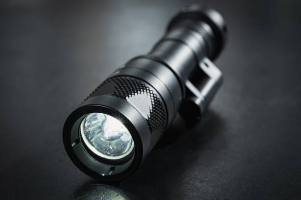 istock Turned on tactical flashlight, close-up photo. 1824331697