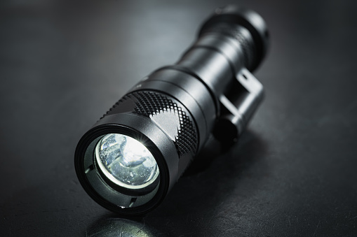 Turned on tactical flashlight, close-up photo. High quality photo