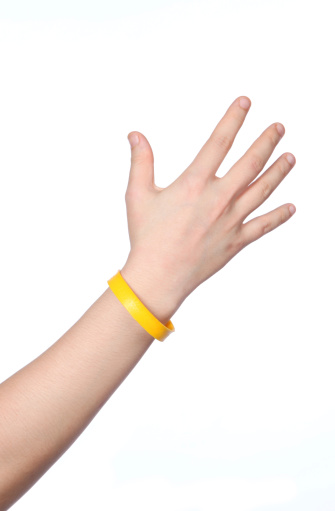 yellow wristband as symbol to support cancer awareness