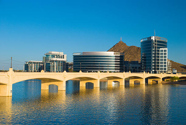 Tempe skyline, river, and bridge "The Phoenix suburb / satellite city of Tempe, with the Tempe city skyline, Hayden Butte (hill), Tempe Town Lake (part of Salt River), and Mill Avenue Bridge" tempe arizona stock pictures, royalty-free photos & images