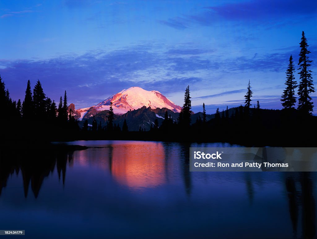 Mount Rainier at Dawn from Tipsoo Lake Mount Rainier reflects the warm glow of dawns light in the qualm waters of Tipsoo Lake at Mount Rainier National Park, WA Lake Stock Photo