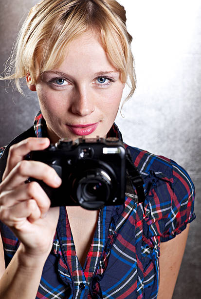 istock cute blond curly young woman with a camera 182434456