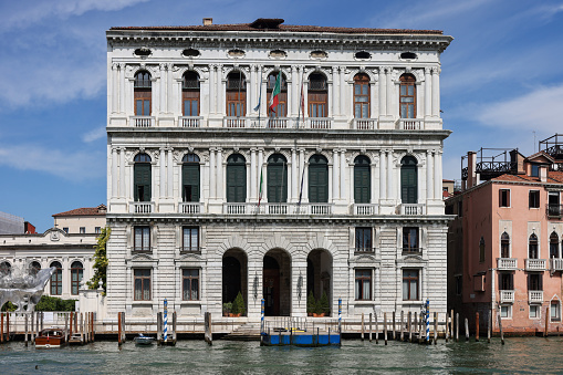 Venice, Italy – August 15, 2017:  Giant hands rise from the water of Grand Canal to support the building in Venice. This powerful report on climate change from Lorenzo Quinn. Modern art in Venice.