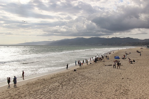 Los Angeles, United States – May 06, 2019: A scenic beach with many people leisurely strolling along the sandy shoreline