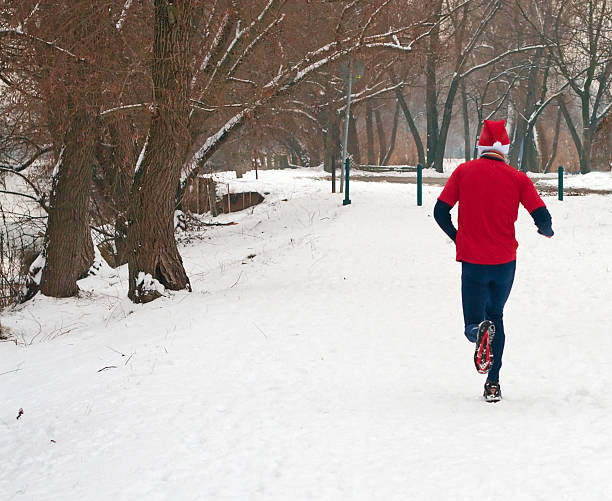 Man in red running in the snow stock photo
