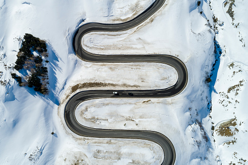Winding mountain pass in the Swiss Alps in winter viewed from directly above.