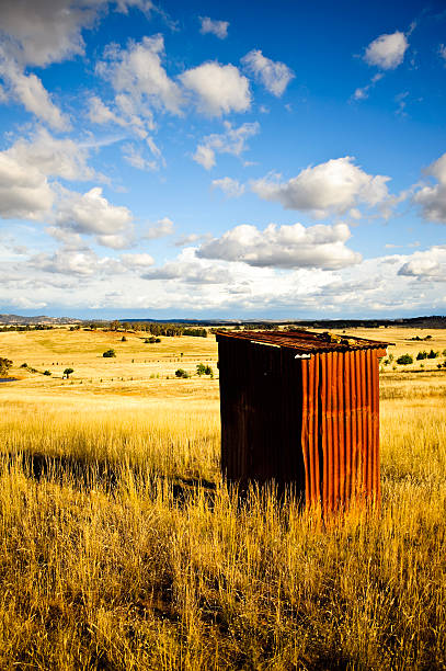 australia, rusty hierro ondulado eliminar farm excusado exterior - metal tin cloud vertical fotografías e imágenes de stock