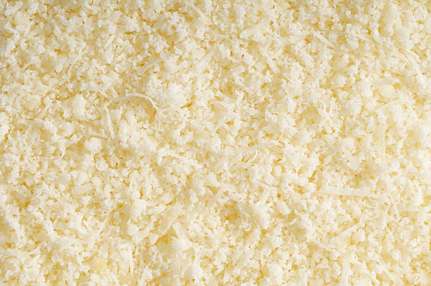 Parmesan Background Grated parmesan filling the frame. grated stock pictures, royalty-free photos & images