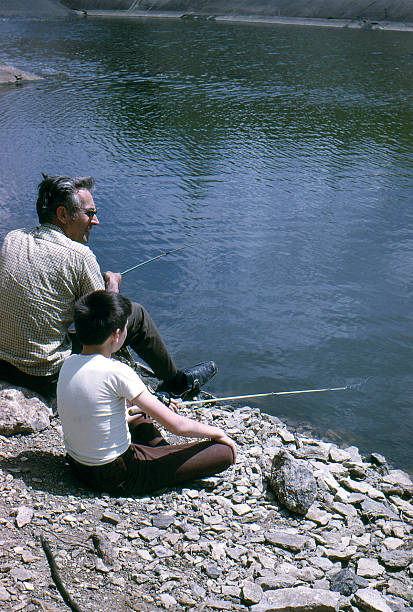 vater und sohn beim angeln 1974, retro - fischen fotos stock-fotos und bilder