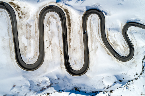 Top down view of winding mountain pass in the Swiss Alps in winter.