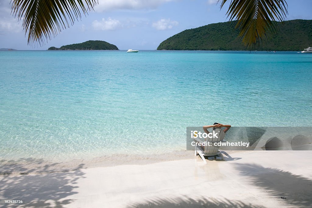 Mujer tomando el sol en una silla en la playa - Foto de stock de Playa libre de derechos