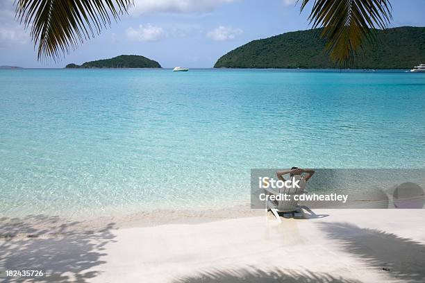 Mujer Tomando El Sol En Una Silla En La Playa Foto de stock y más banco de imágenes de Playa - Playa, Cóctel - Bebida alcohólica, Caribe