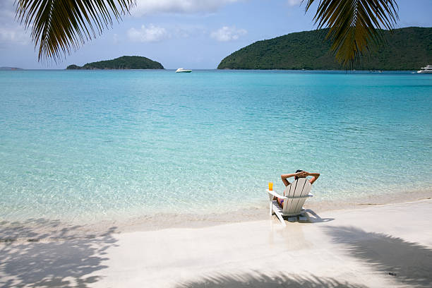 femme au soleil sur un transat sur la plage - swimwear caribbean sea beach water photos et images de collection