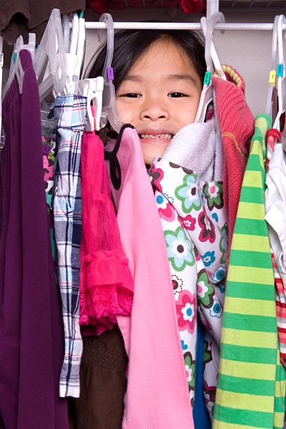 istock Cute girl behind clothes in closet 182436354