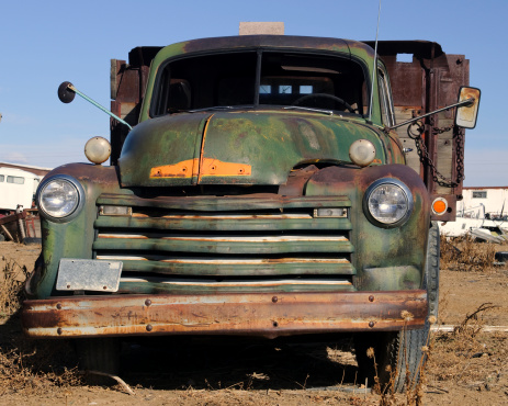A high dynamic range image of a salvaged green truck.