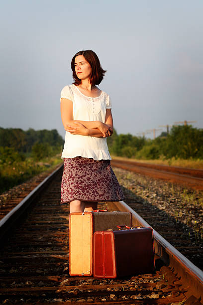 istock Lonely woman standing on a railroad track 182437813
