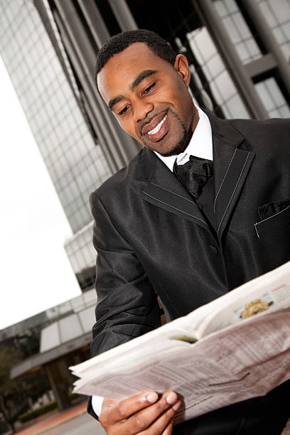 istock Businessman Reading Newspaper Outside Office Building 182438060