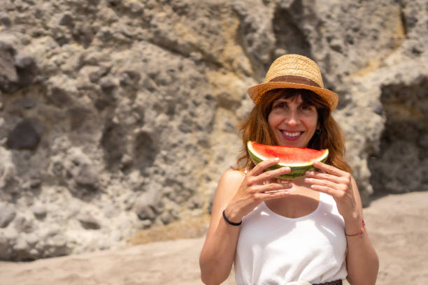 istock Woman enjoying a watermelon on the beach 1824380679