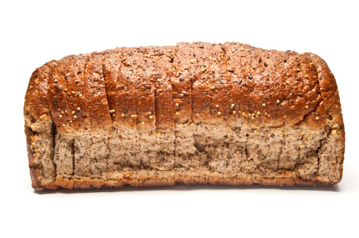 A Sliced Loaf of Seeded Brown Bread isolated on white