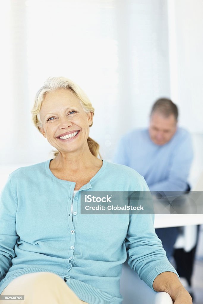 Hermosa Mujer sonriendo con un hombre en el fondo - Foto de stock de 50-59 años libre de derechos