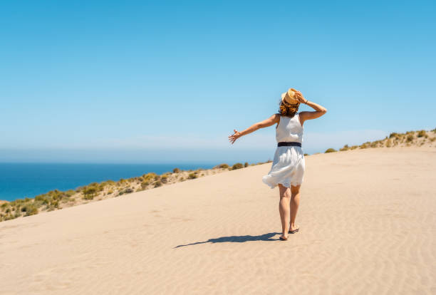 istock Woman walking along a coastal path in a windy day 1824388081