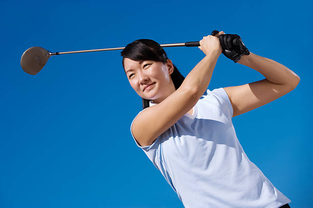 istock Young female golfer teeing off 182440110