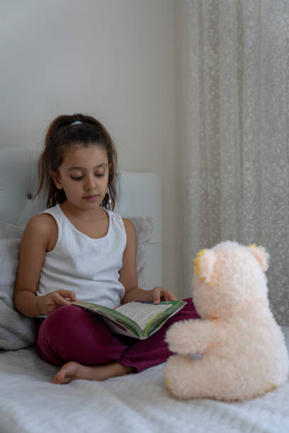 istock Girl playing with teddy bear in her room. 1824404842