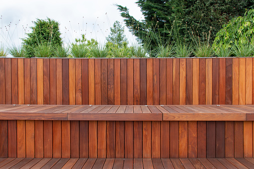 Wooden board fence cladding and decking, garden greenery on top, horizontal and vertical lines