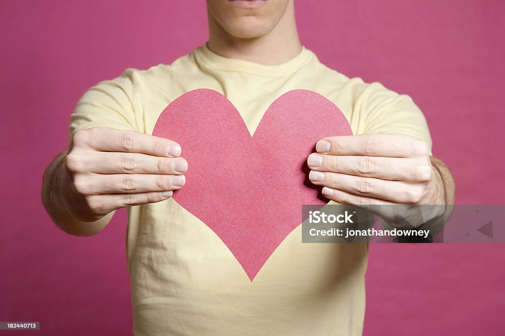 Jeune homme tenant en forme de cœur rose - Photo de Adulte libre de droits