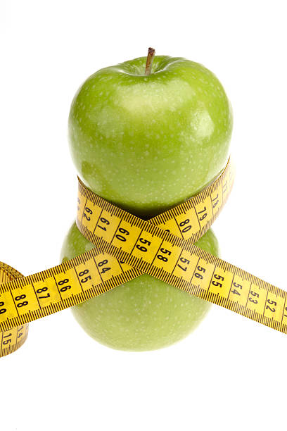 istock Green apples with centimeter tape measure vertical 182441008