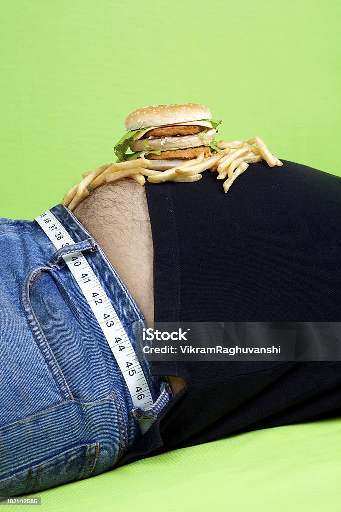 Hamburguesa y papas fritas coloca en el estómago - Foto de stock de Hombres libre de derechos
