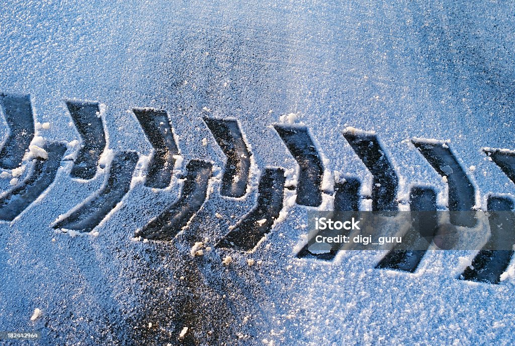 Winter Traction A snow tractor's tread pattern is left behind on a freshly plowed roadway in this wintery abstract. Tire Track Stock Photo