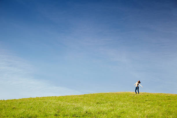 istock Woman in Meadow With Arms Outstretched 182443828