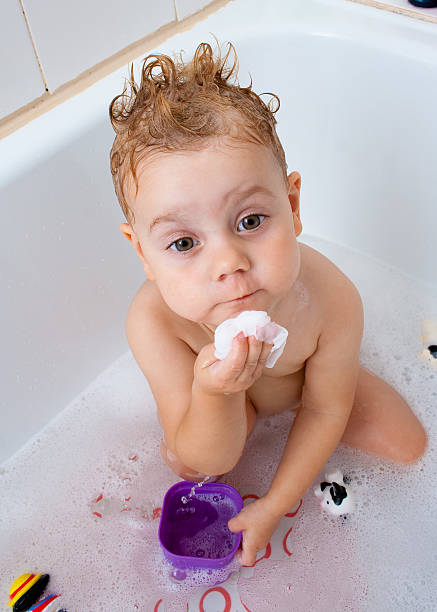 Baby girl in the bath stock photo