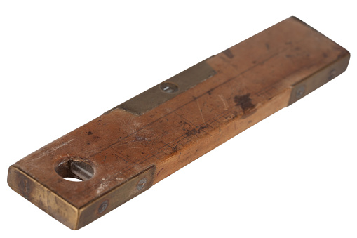 Antique carpenter's boxwood ruler with spirit level from 19th century isolated on white background.