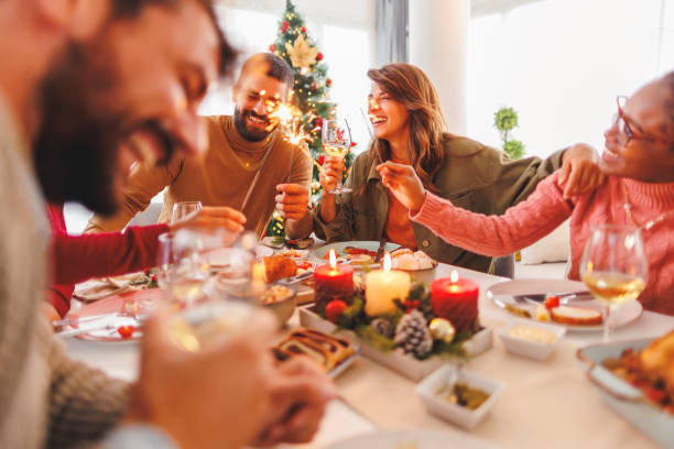 istock Friends celebrating Christmas together at home, waving with sparklers while having dinner 1824456380