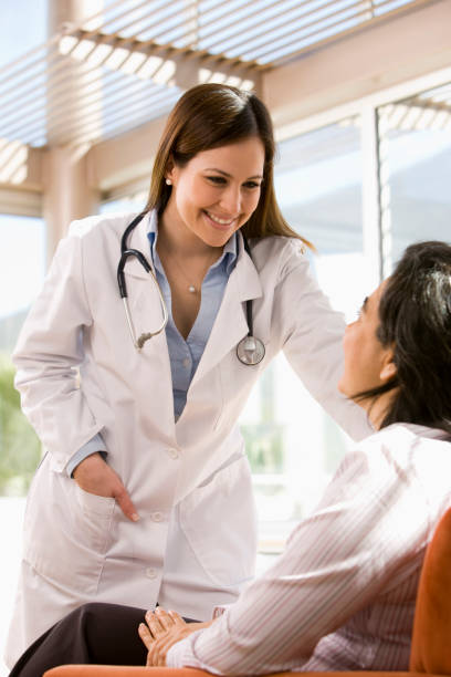 Smiling female doctor talking to patient outdoors stock photo